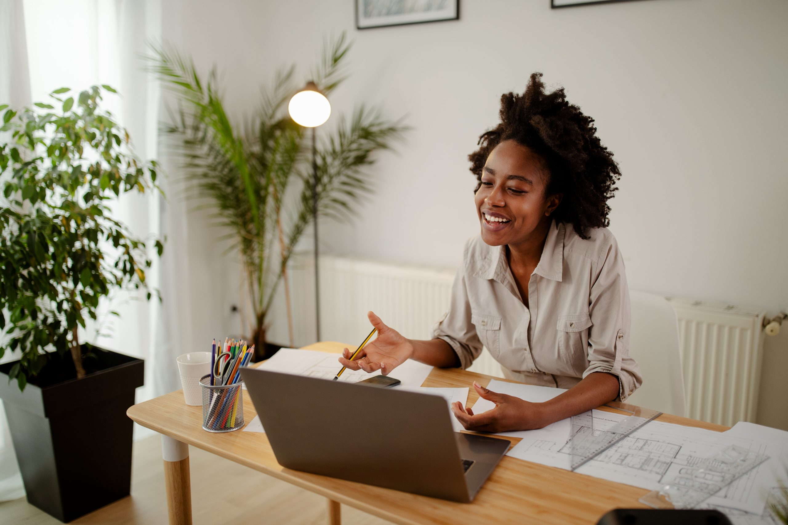 Image of happy black woman, smiling while speaking or chatting on video call in office.